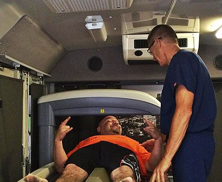 Jay Glazer laying in a hyperbaric chamber with a medical professional.
