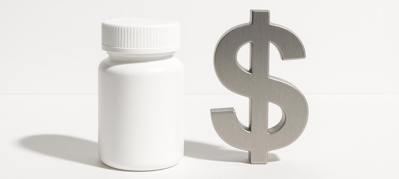 A white, unmarked prescription bottle stands next to a large, metallic silver dollar sign against a plain white background, symbolizing the high cost of medications.