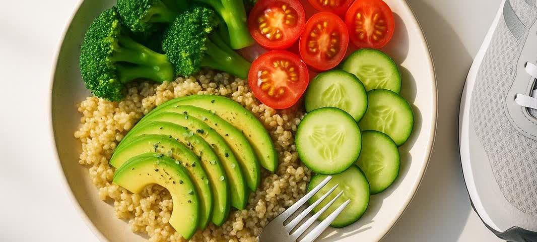 A healthy plate of food sits next to a pair of running shoes, representing diet and exercise for health.